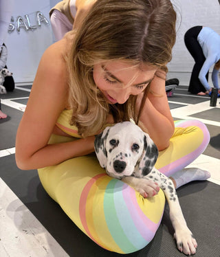 A woman doing yoga with puppies