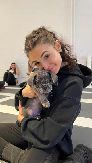 Dog yoga with an adorable puppy and a happy woman