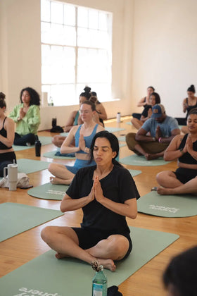 Group of people performing flow yoga at Wellness Puppy Yoga.